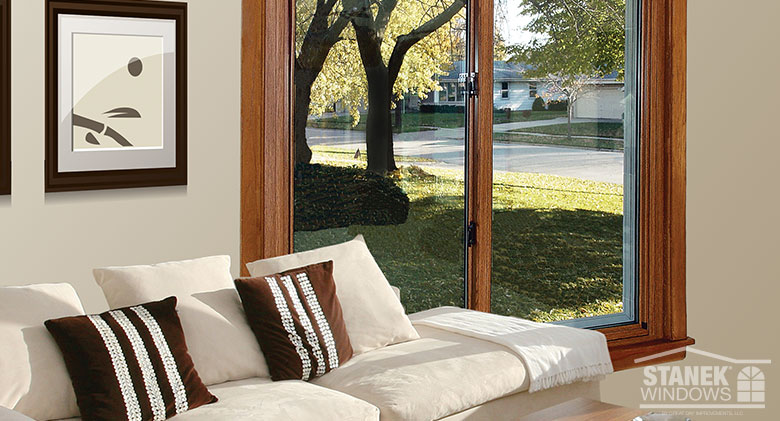 Sliding window from inside a living room with a white couch and brown and white striped pillows
