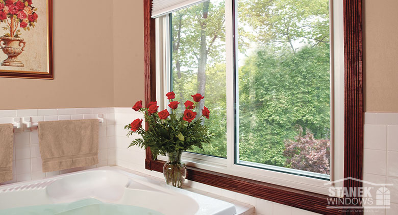 White framed two-lite sliding window in a bathroom next to a white bathtub