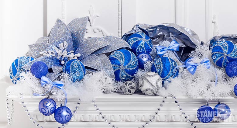 Window box decorations of ornaments, beads, poinsettias, and evergreen branches in blue, white, and silver for Hanukkah.