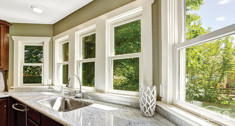 A row of double-hung windows over the sink and counter in a kitchen.