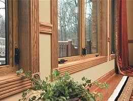 Storm windows with natural wood stained trim