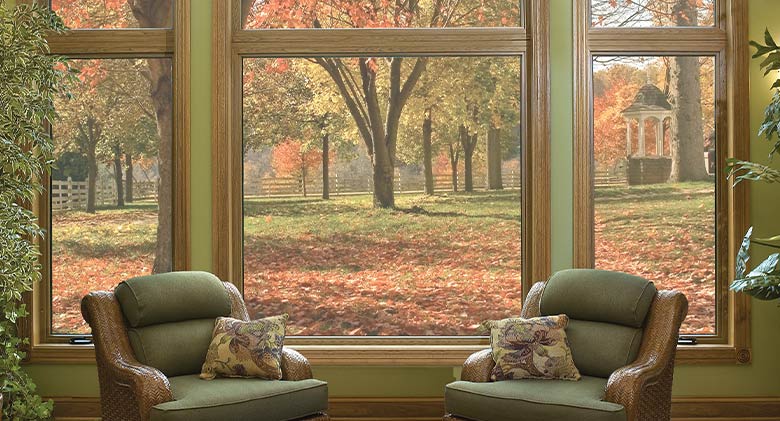 A picture window flanked by casements showing an expansive backyard view.